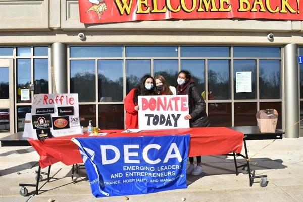 Members of the East High School DECA club collect donations for Home of the Sparrow 